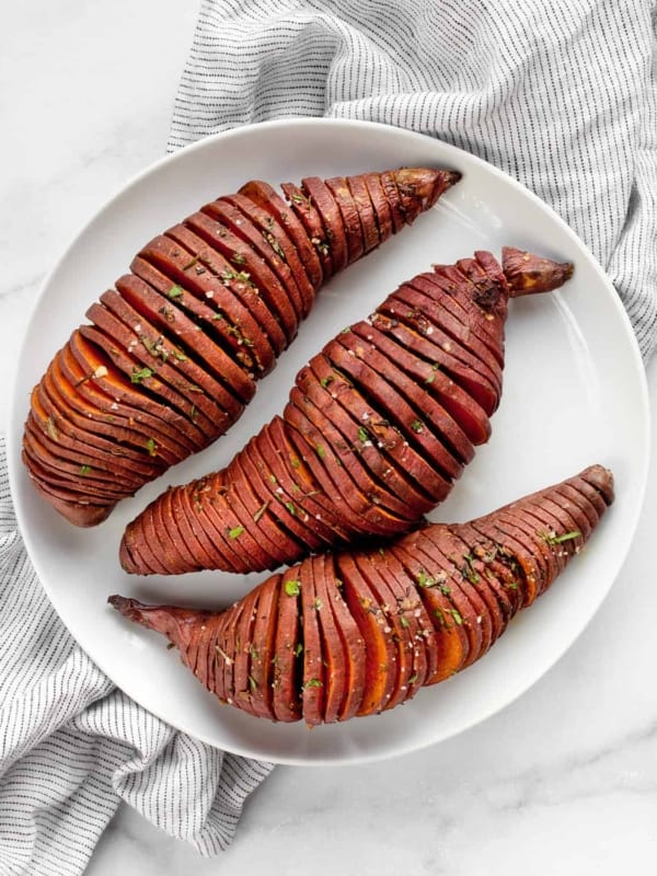 3 hasselback sweet potatoes on plate.