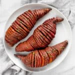 3 hasselback potatoes on a plate.