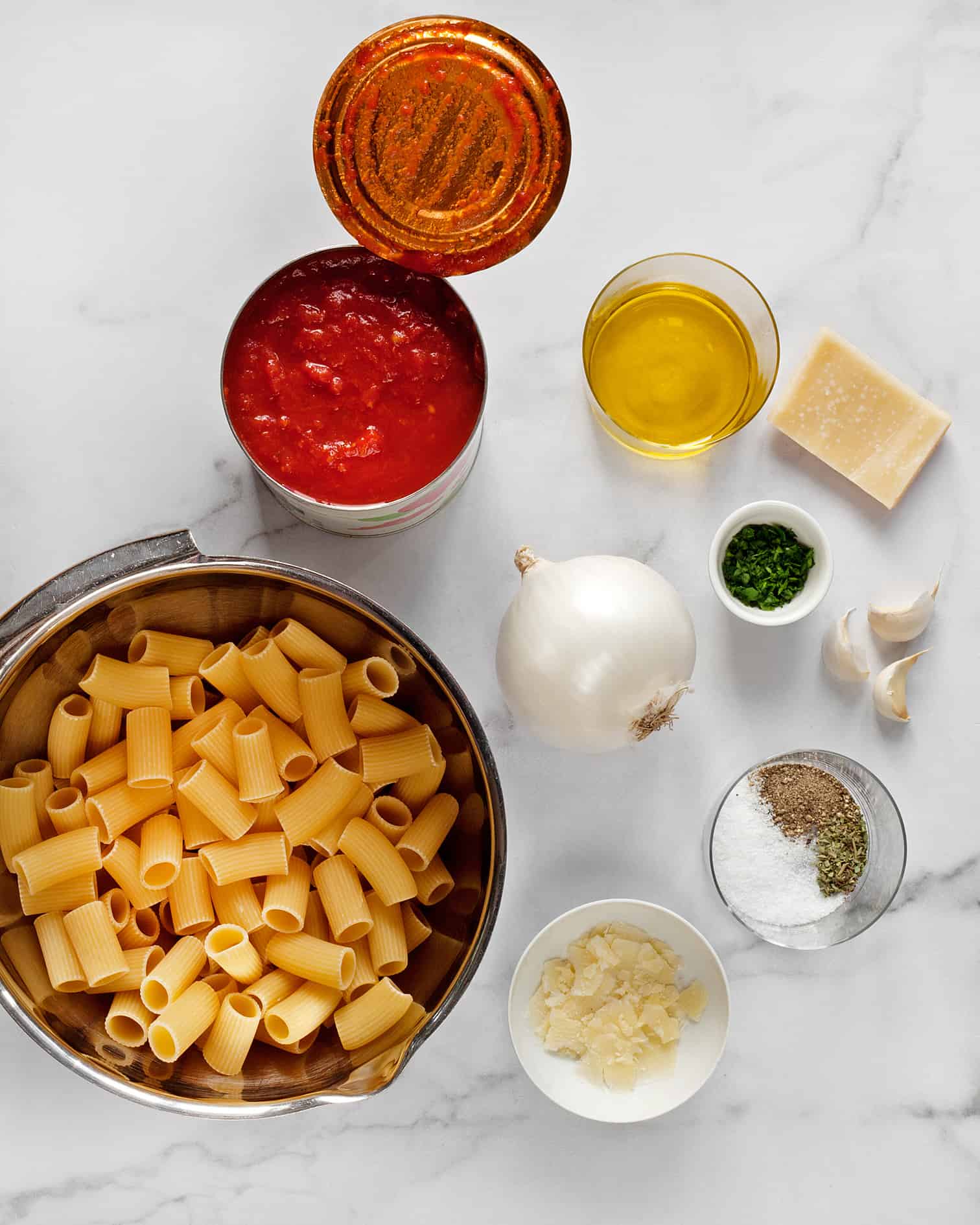 Ingredients including pasta, canned tomatoes, onion, garlic and spices