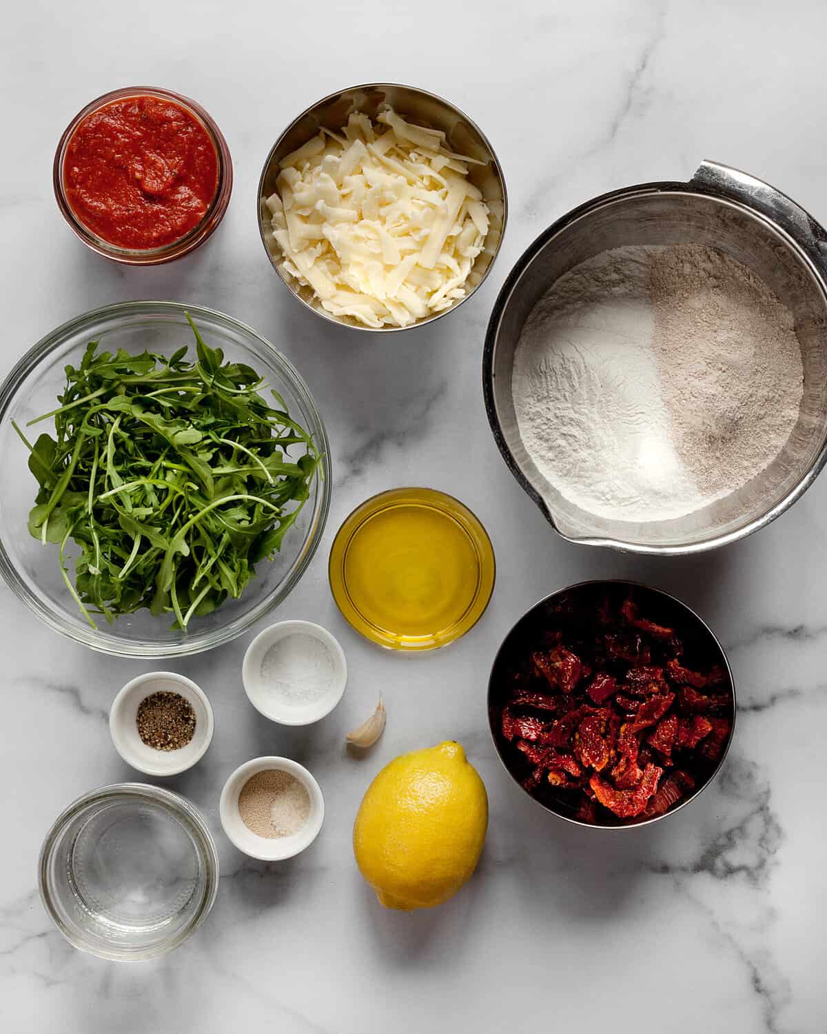 Ingredients including arugula, tomatoes, suae, flour and olive oil