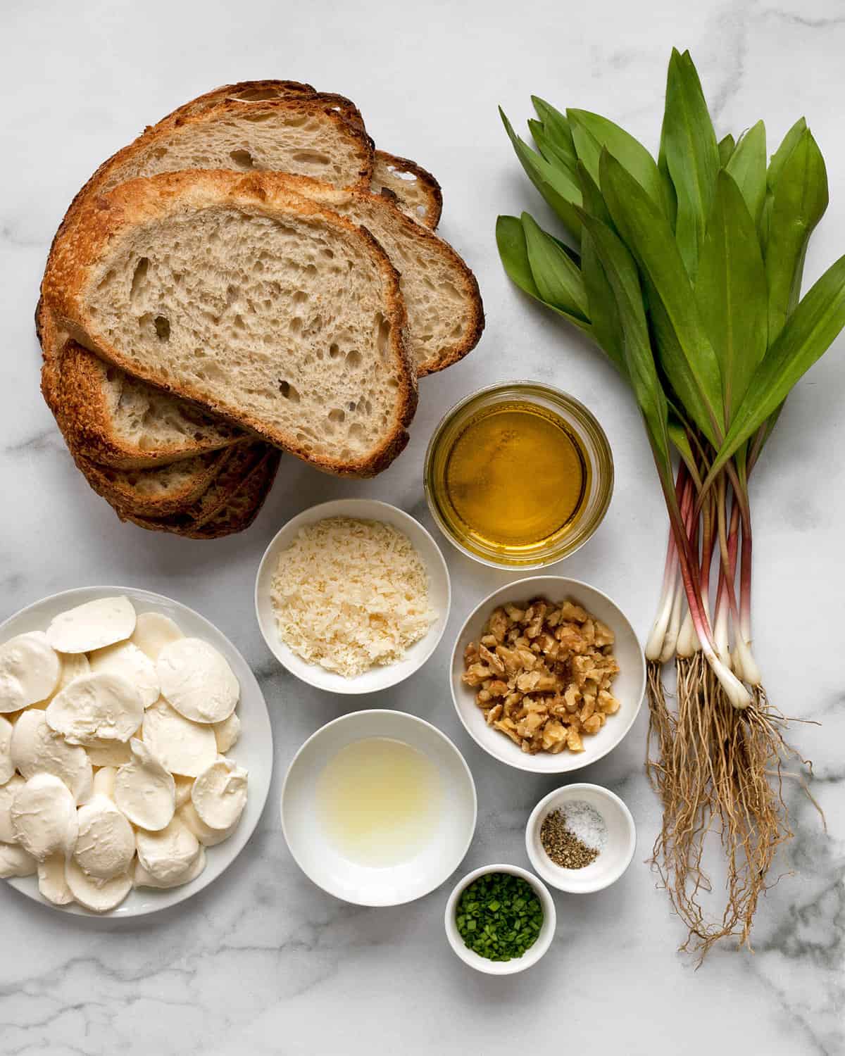 Ingredients including bread, ramps, mozzarella, walnuts, olive oil, lemon juice, Parmesan, chives, salt and pepper