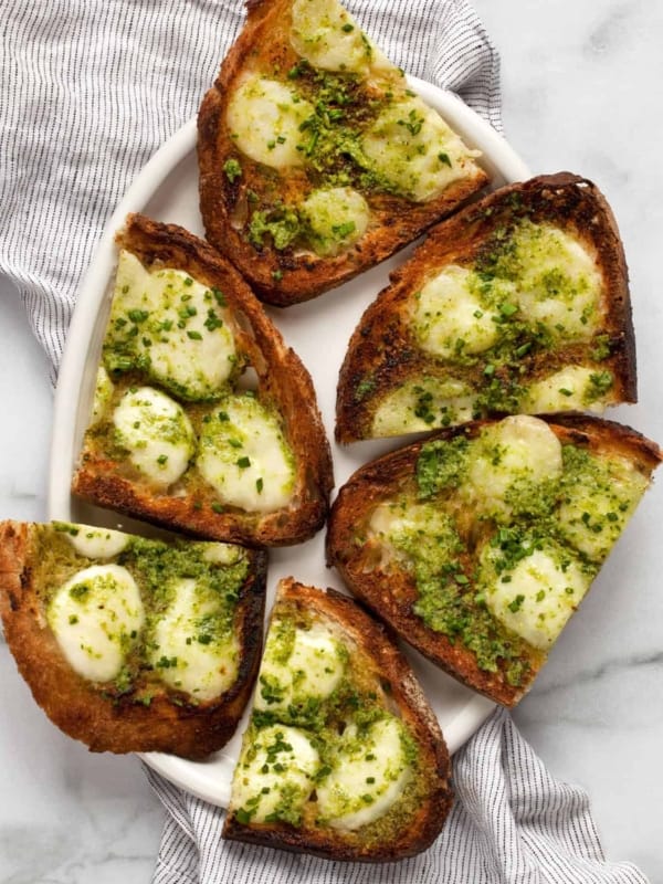 Pesto garlic bread slices on a plate.