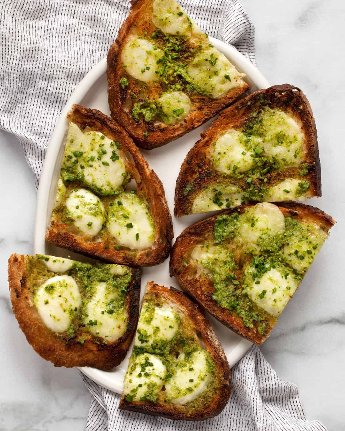 Pesto garlic bread slices on a plate.