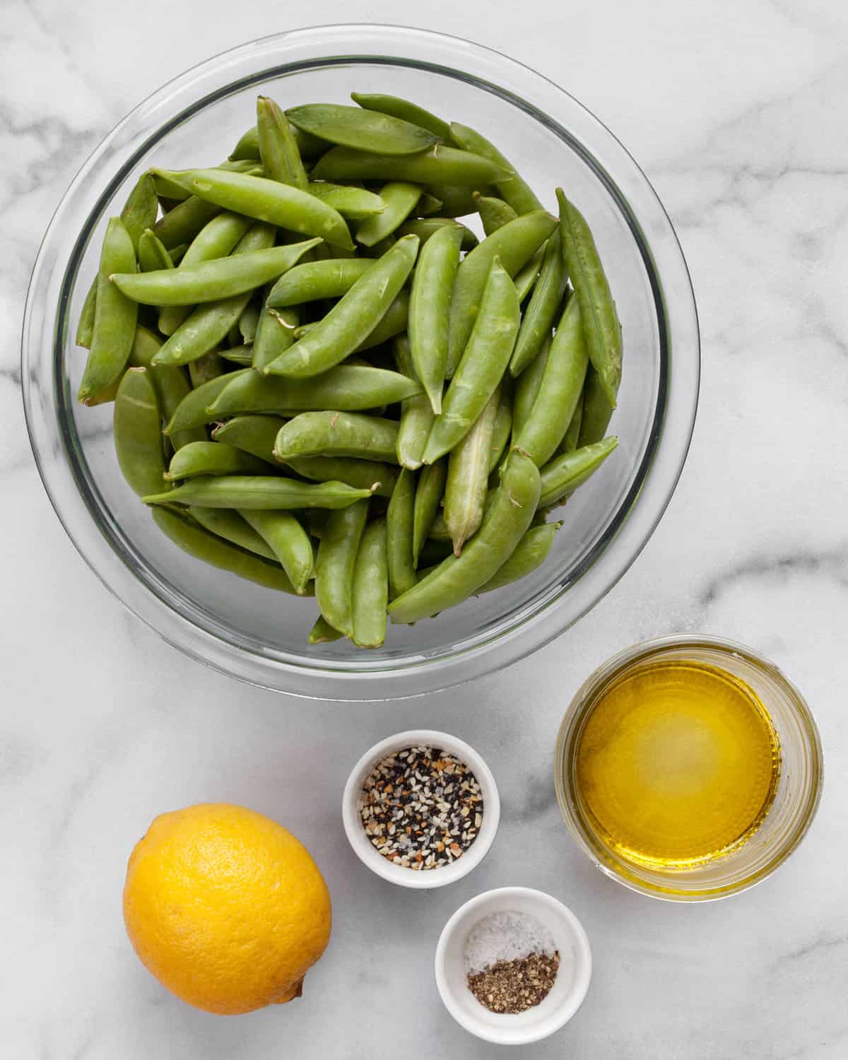 Ingredients including snap peas, lemon, olive oil, salt, pepper and everything seasoning.