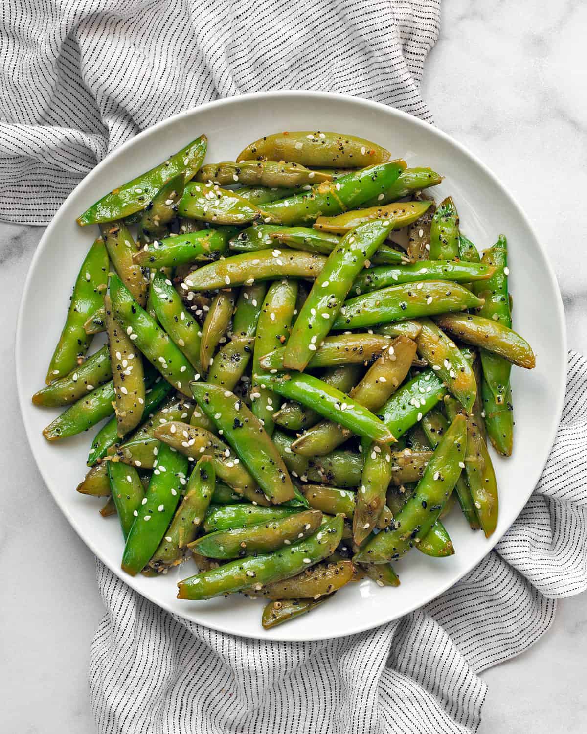 Sautéed sugar snap peas on a plate.