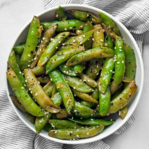 Sautéed snap peas in a bowl.