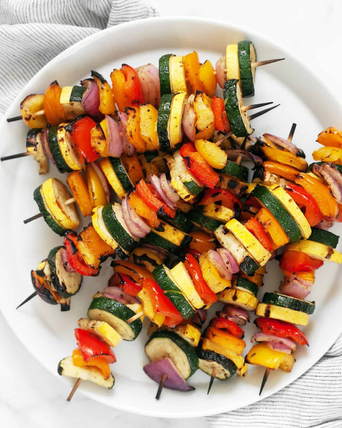 Balsamic grilled vegetable skewers on a plate.