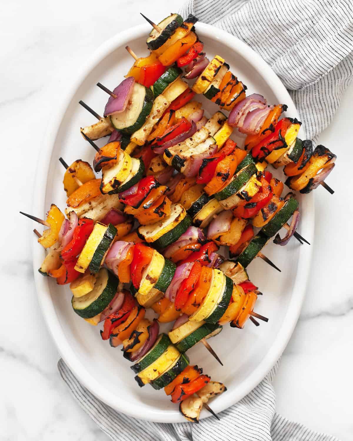 Balsamic grilled vegetable skewers on an oval serving platter.