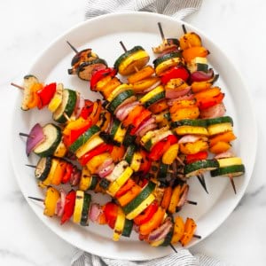 Balsamic grilled vegetable skewers on a plate.