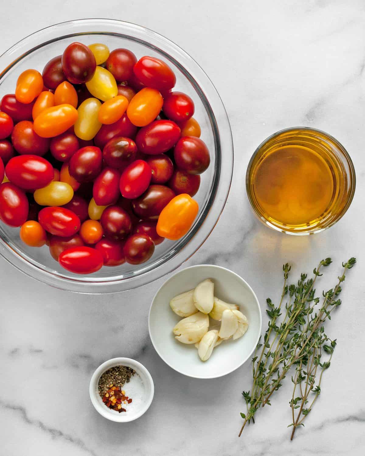 Ingredients including tomatoes, garlic, olive oil, thyme, salt and pepper.