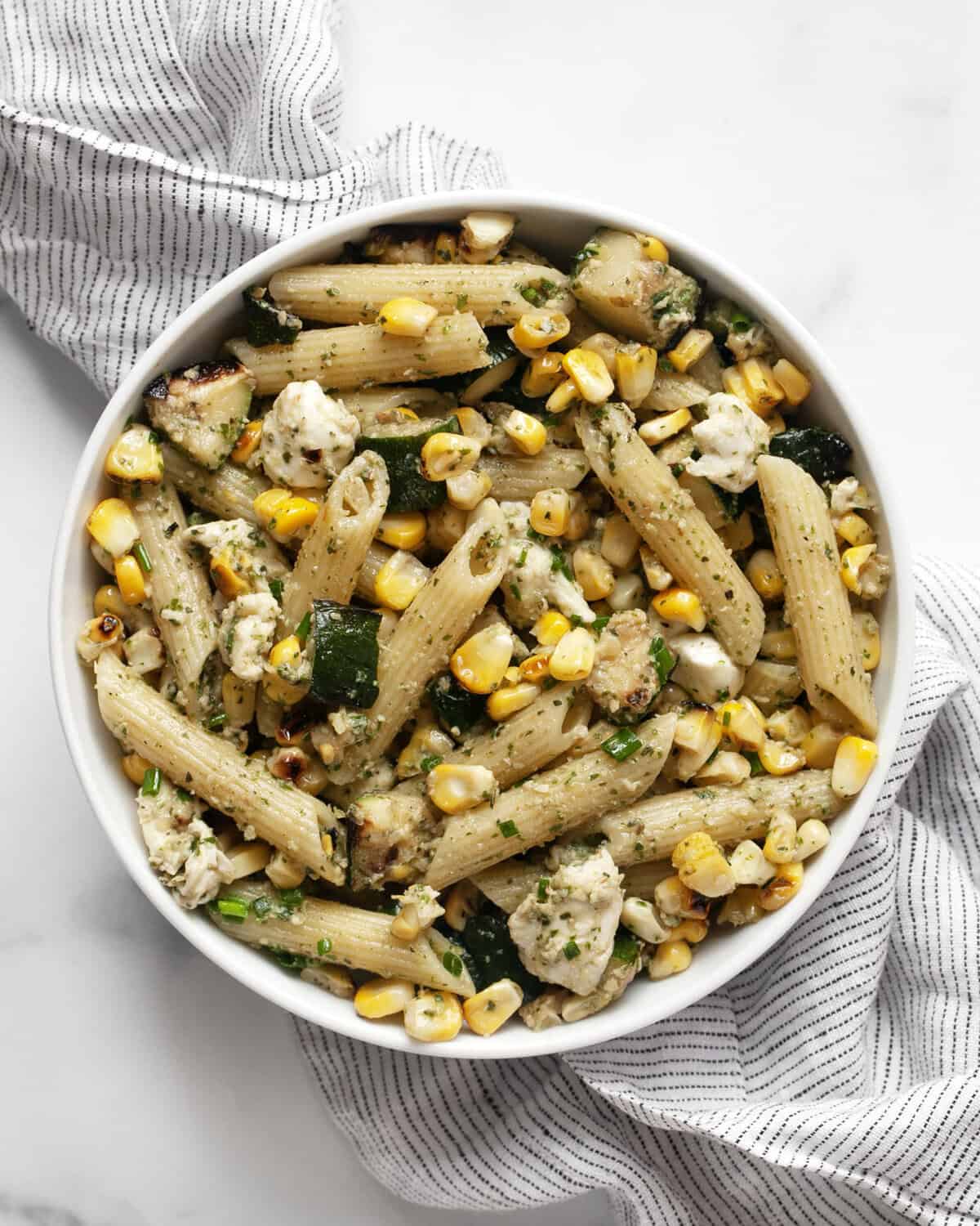 Grilled zucchini corn pasta with mint pesto in a bowl.