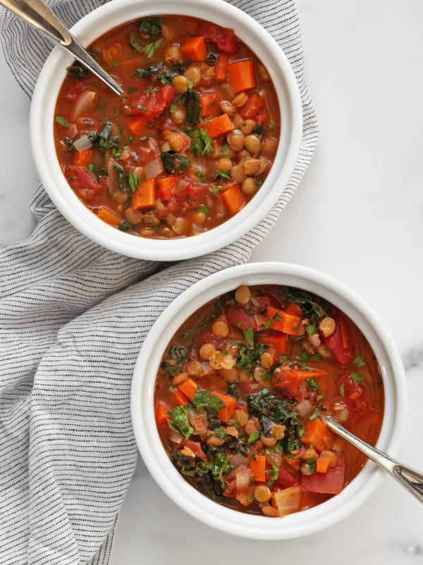 Two bowls of tomato carrot lentil soup.