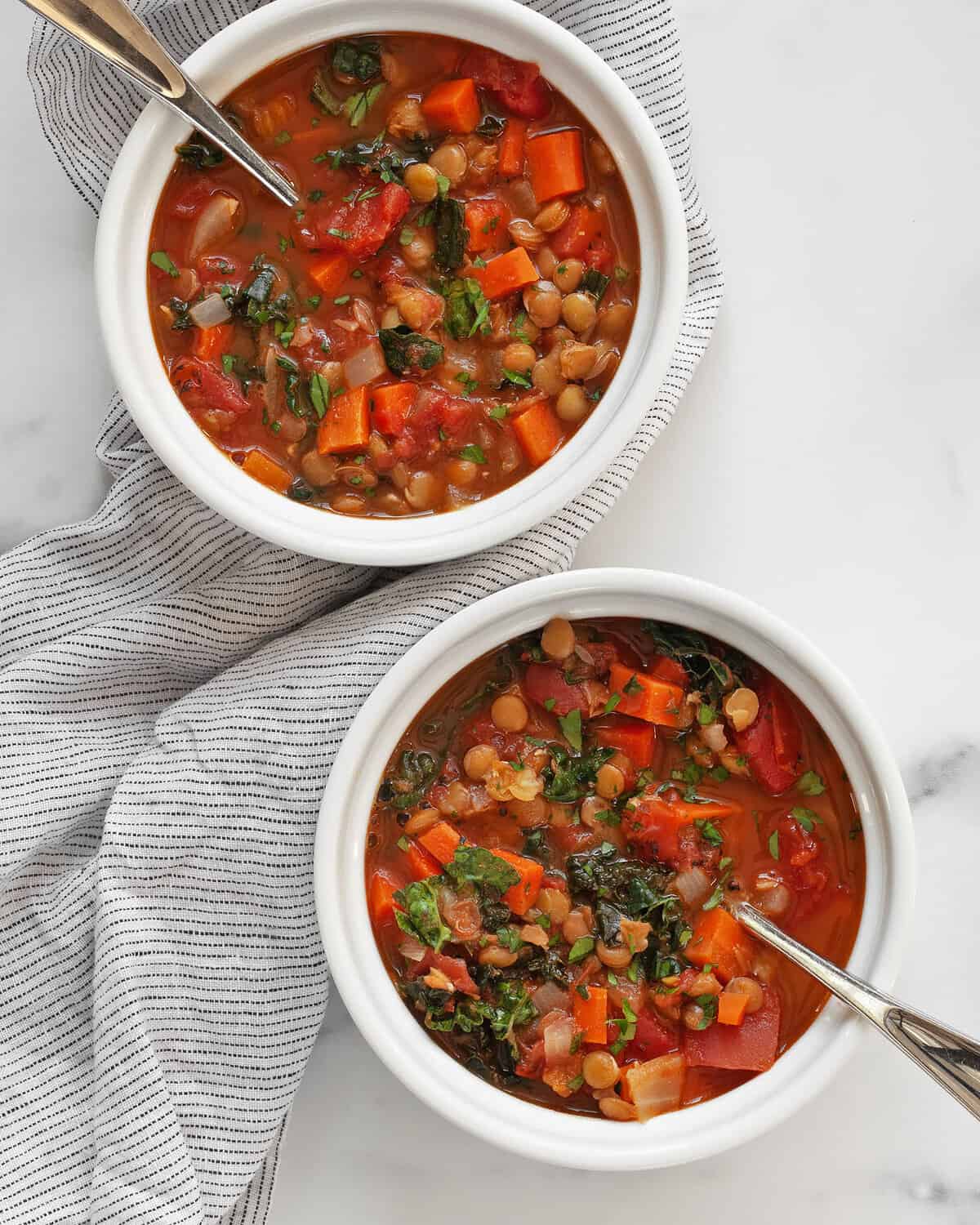 Two bowls of tomato carrot lentil soup.