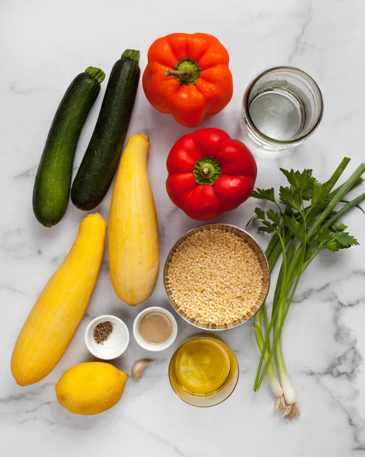 Ingredients including zucchini, peppers, squash, scallions, parsley, lemon and tahini.