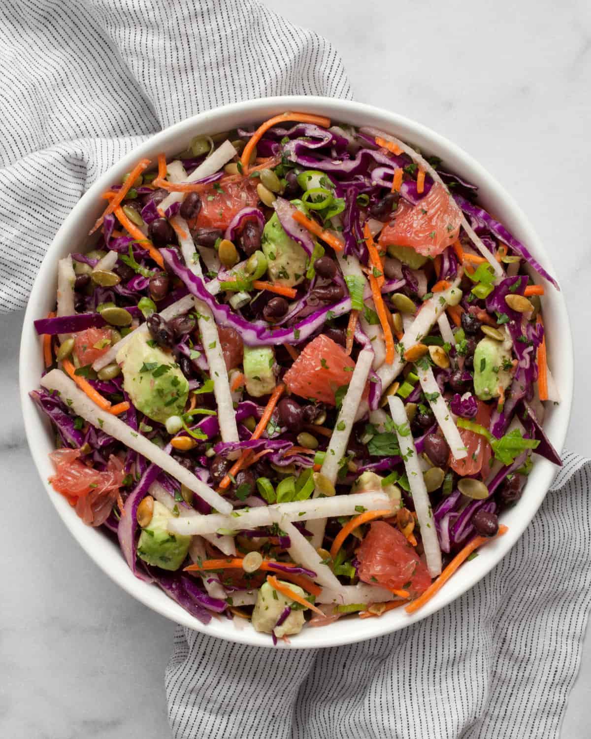 Jicama salad with grapefruit and cabbage in a bowl.