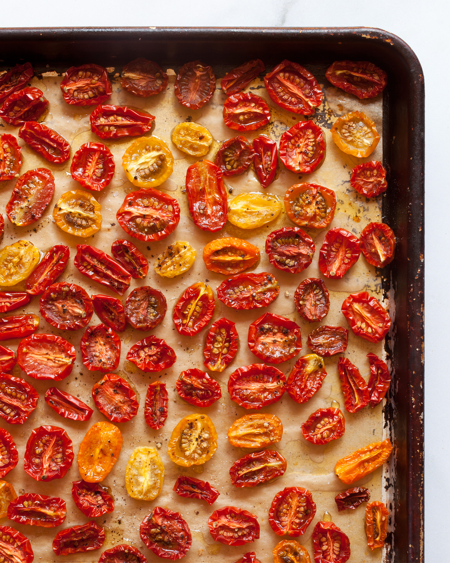 Slow-roasted tomatoes on a sheet pan.