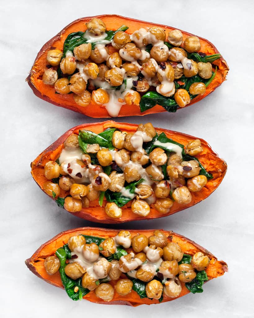 3 sweet baked sweet potato halves with crispy chickpeas, spinach and tahini