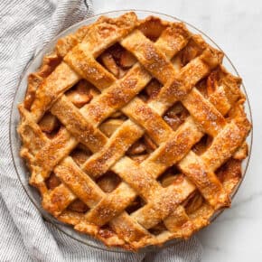 Apple pie in a dish ona cloth napkin.