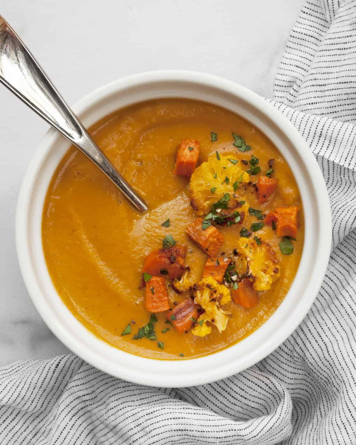 Roasted sweet potato cauliflower soup in a bowl.