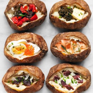 6 baked potatoes all with different toppings.