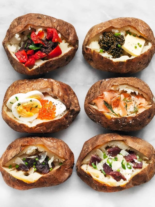 6 baked potatoes all with different toppings.