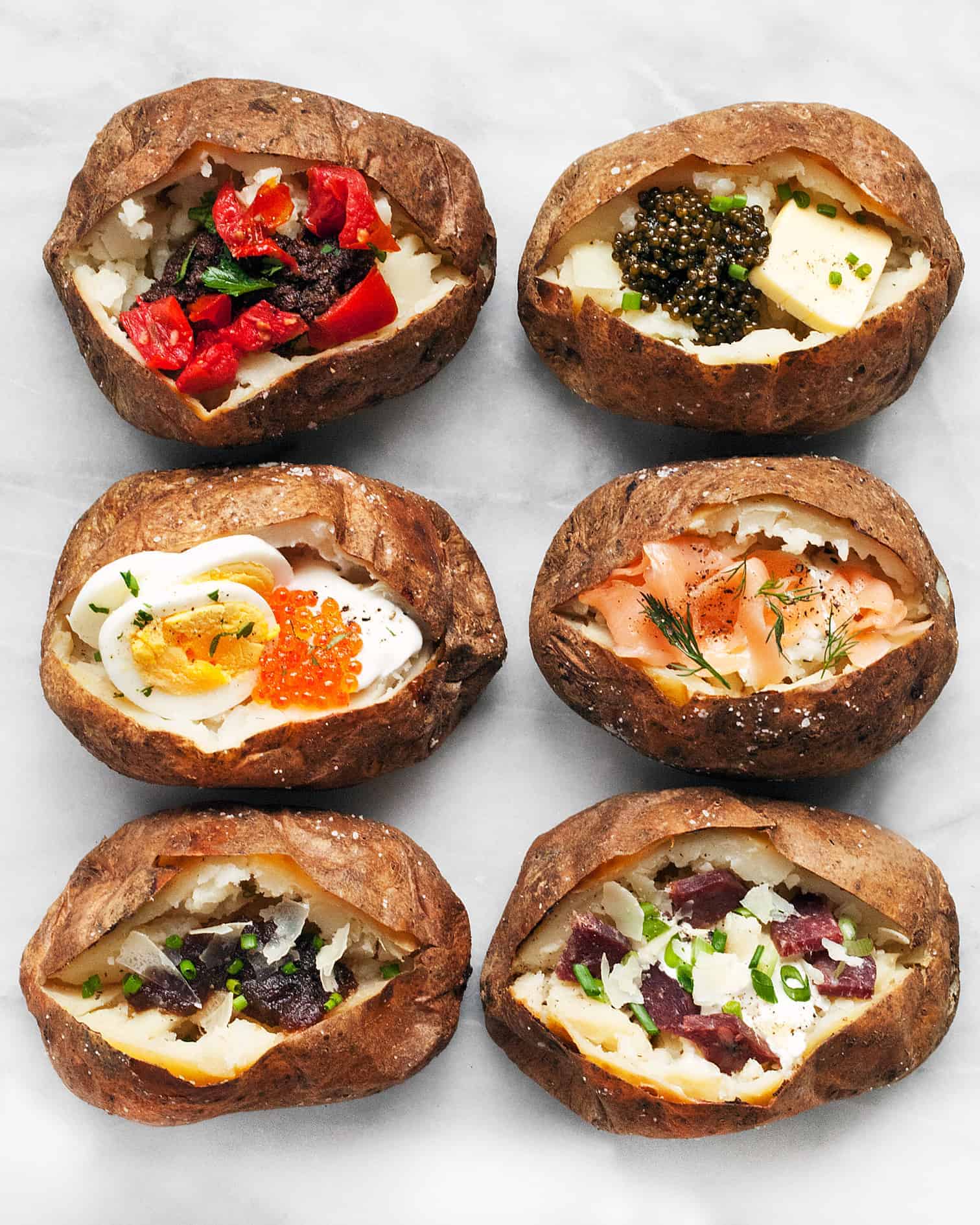 6 baked potatoes all with different toppings.