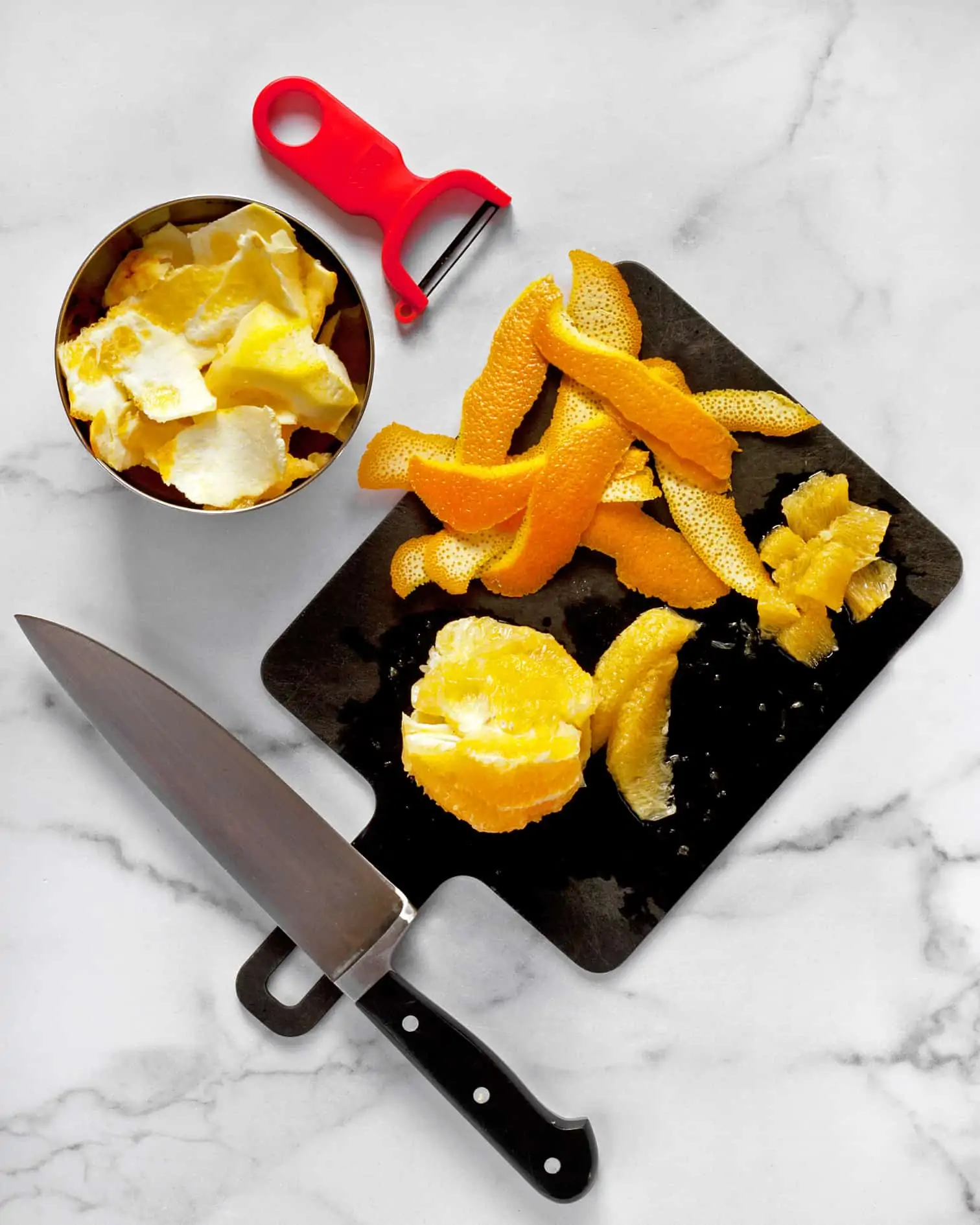 Zesting an orange, removing the pith and cutting the segments on a cutting board