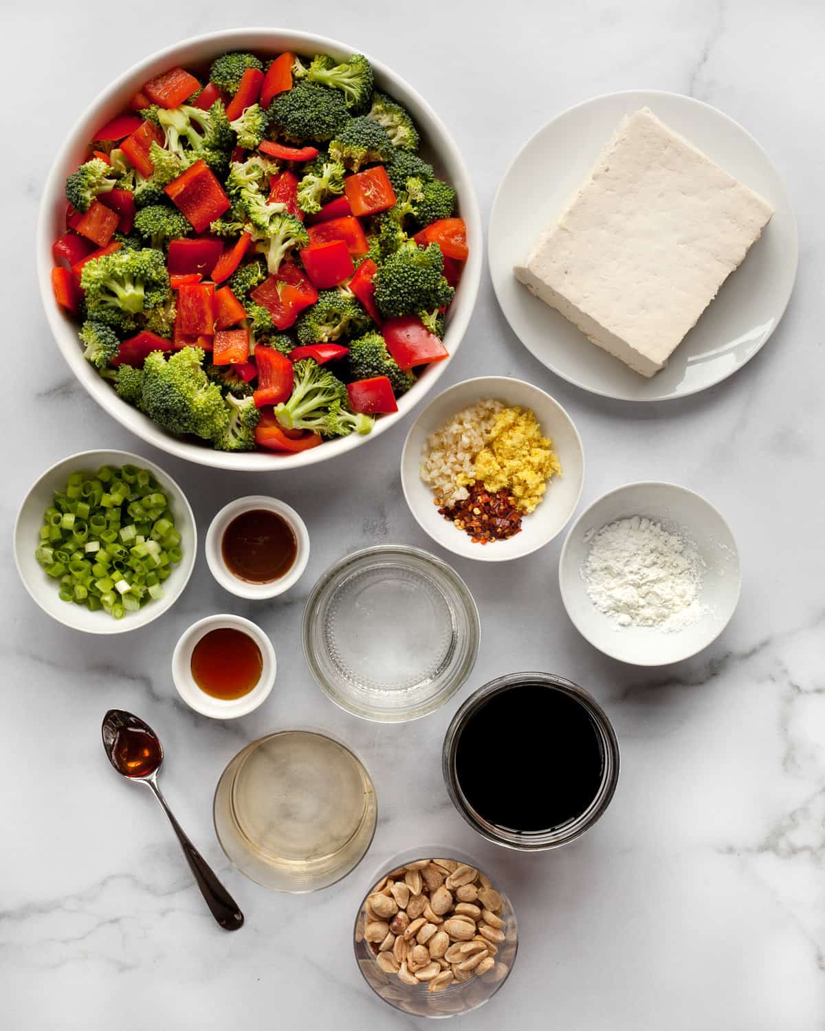 Ingredients including broccoli, peppers, tofu, peanuts, scallions, ginger, garlic, red pepper flakes, peanuts, hoison, sesame oil, rice vinegar, and cornstarch.