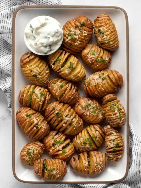 Mini hasselbacks on plate with yogurt dip.