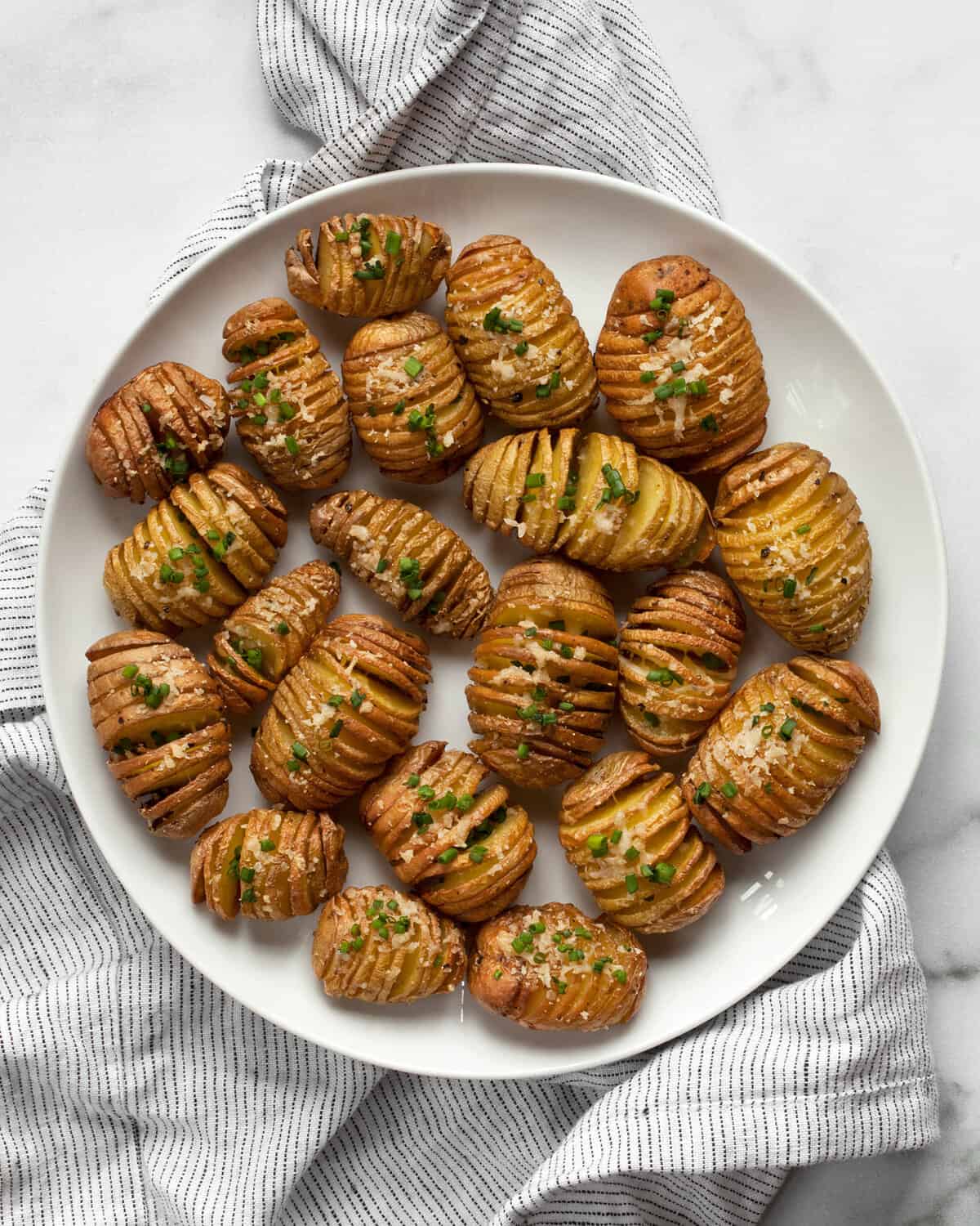 Hasselback potato bites arranged on plate.