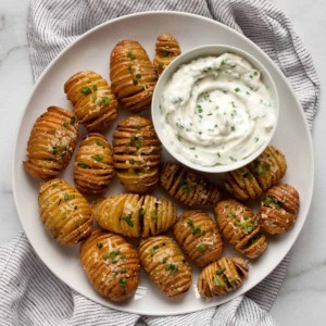 Herby yogurt dip served with mini hasselback potatoes.