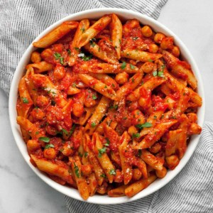 Pasta with chickpeas and spicy tomato sauce in a bowl.