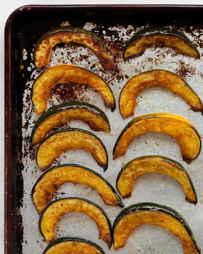 Roasted acorn squash slices on a sheet pan