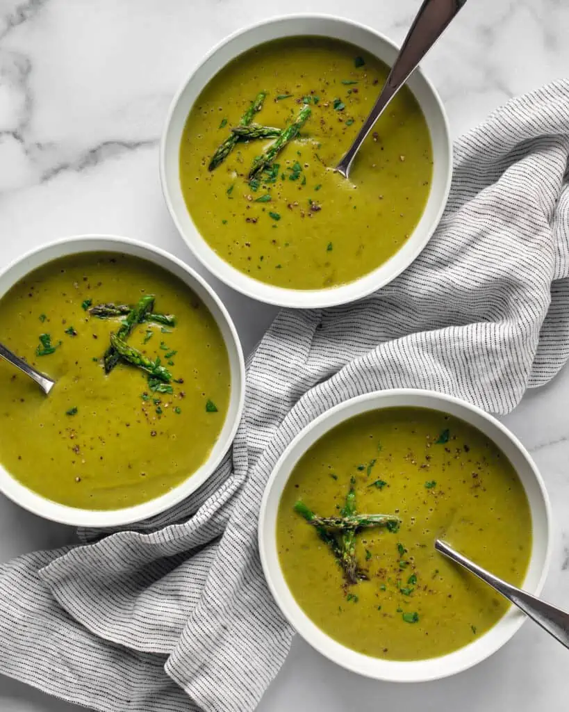 Three bowls of roasted asparagus soup.