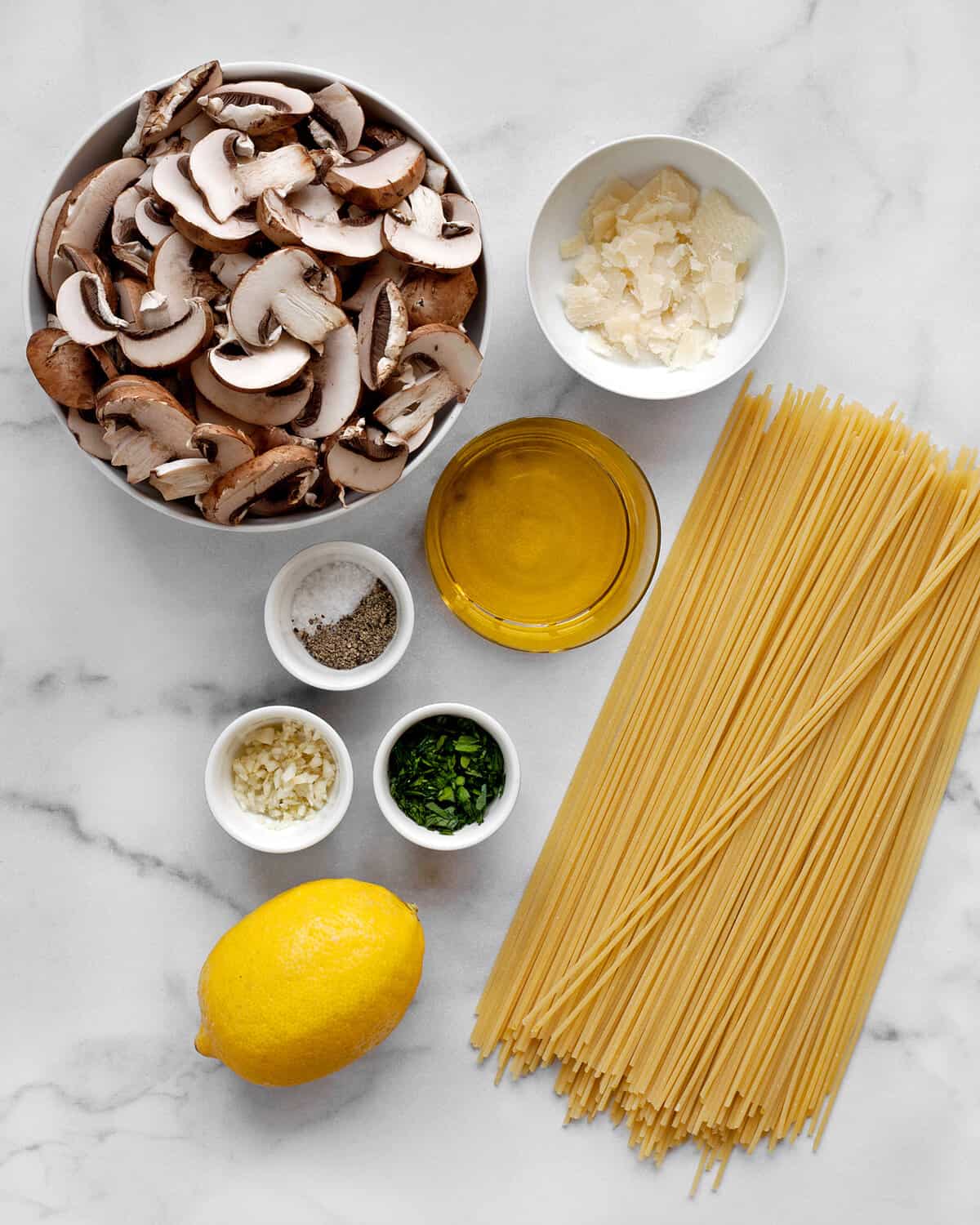 Ingredients including mushrooms, spaghetti, lemon, garlic, olive oil, lemon juice and parmesan.