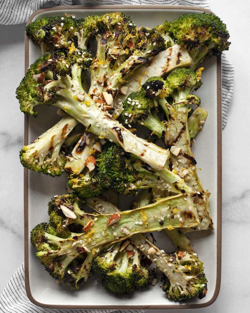 Grilled broccoli on a rectangular serving plate.