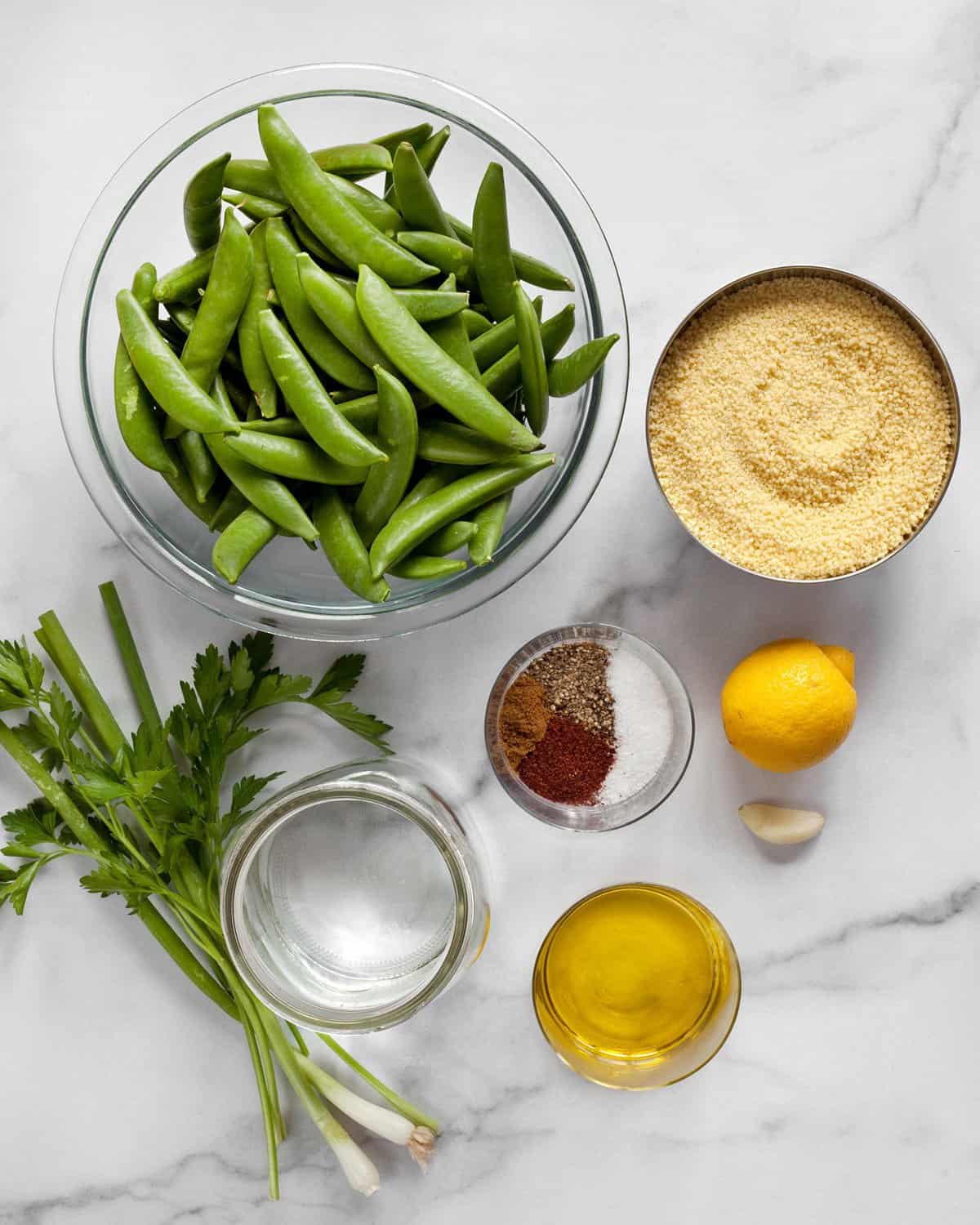 Ingredients including snap peas, couscous, lemon, garlic and spices