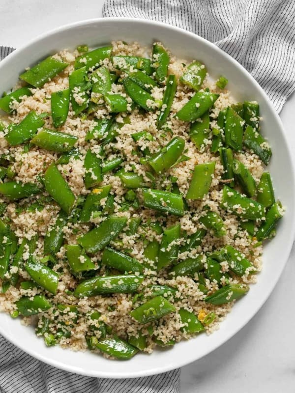Couscous with snap peas on a plate.