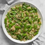 Couscous with snap peas on a plate.