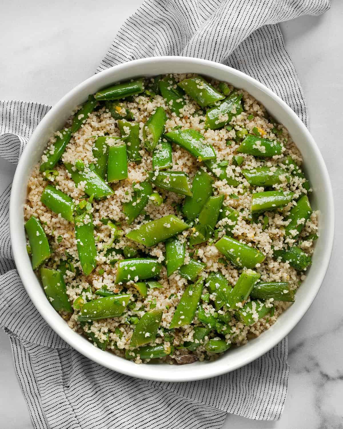 Couscous with snap peas in a bowl.