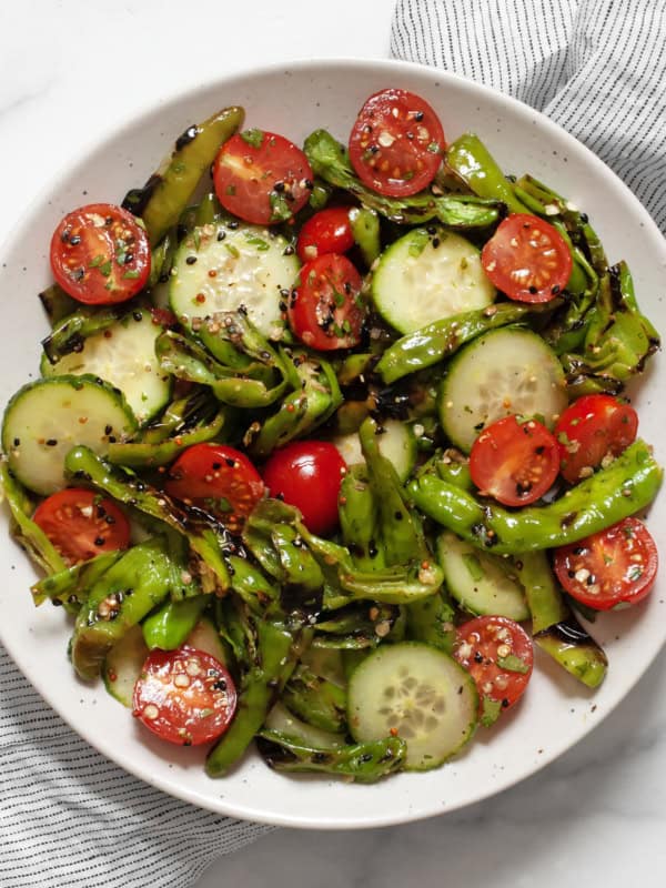 Grilled shishito pepper cucumber salad in a bowl.