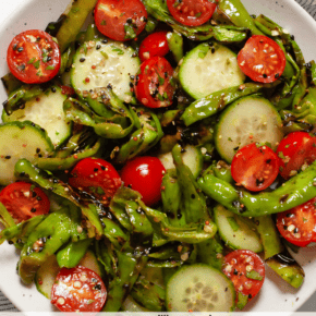 This grilled shishito pepper salad balances smoky heat with crisp, cool freshness. Perfect for summer grilling season, I quickly char halved shishito peppers on the grill. Then I combine them with sliced English cucumbers, cherry tomatoes, cilantro and sesame seeds and toss everything in a light lemon vinaigrette made with rice vinegar. This vegan grilled salad is great for a barbecue side dish or for a healthy lunch. Add it to your list of must-make easy grilling recipes.
