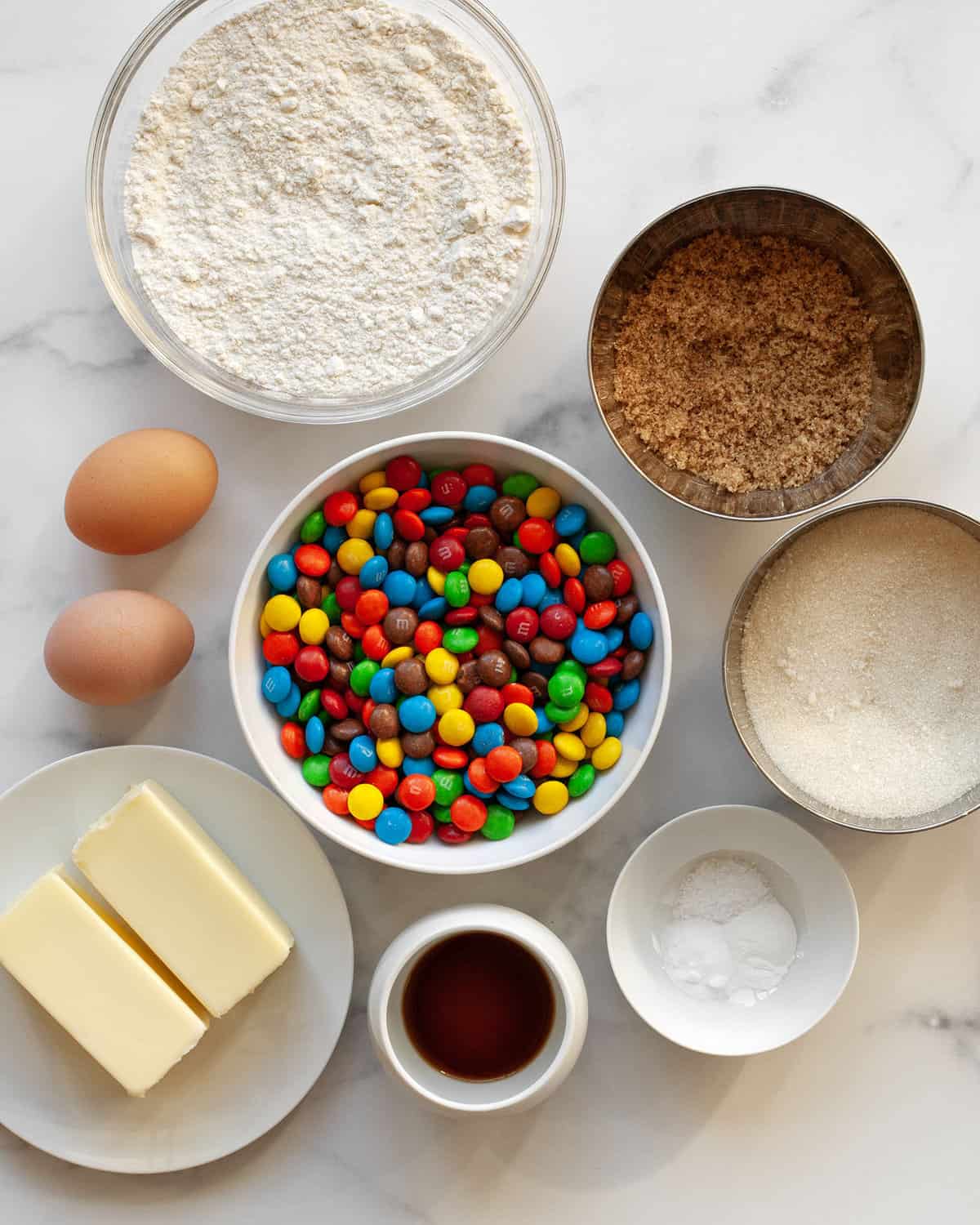 Ingredients including m&ms, flour, sugar, butter, vanilla extract, eggs, baking powder, baking soda and salt.