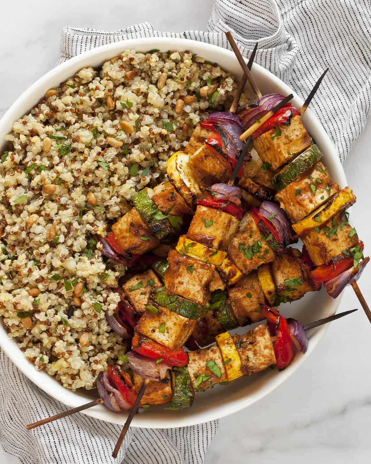 BBQ tofu veggie skewers with herby quinoa in a bowl.