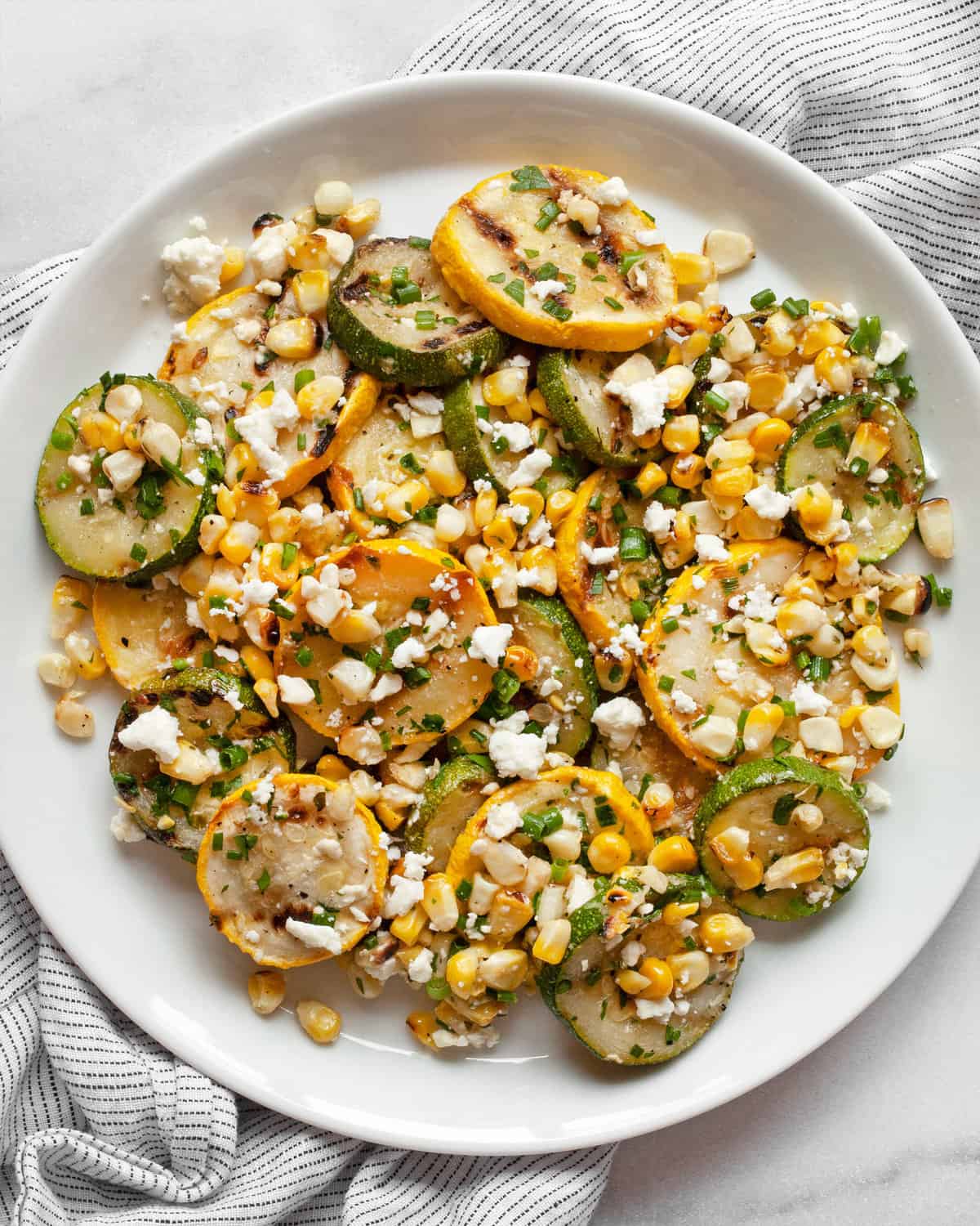 Grilled zucchini, squash and corn on a plate.