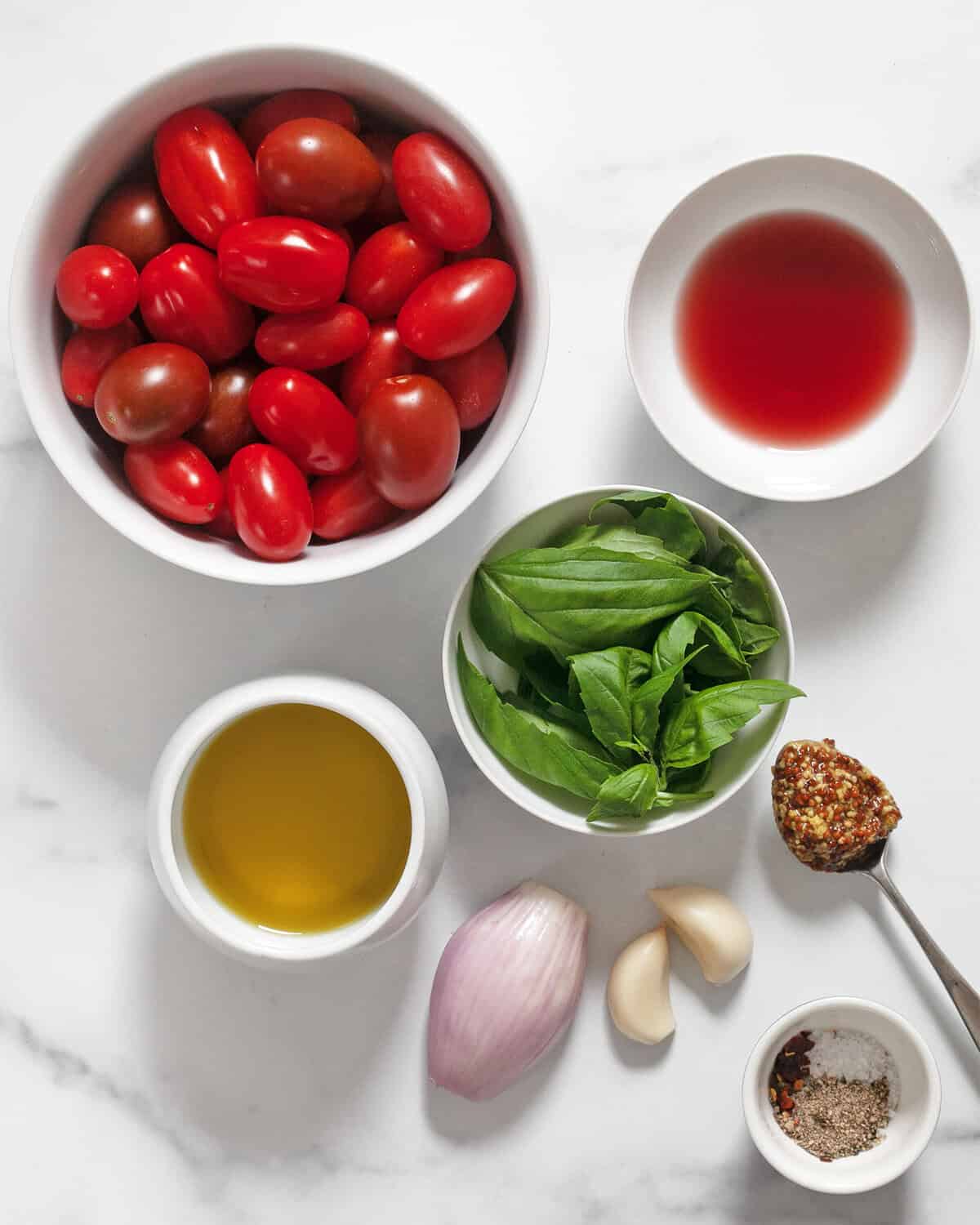 Ingredients including tomatoes, basil, red wine vinegar, olive oil, garlic, mustard and seasonings.