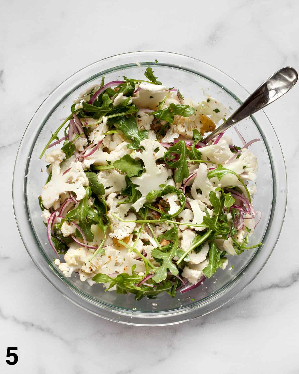 Vinaigrette stirred into cauliflower salad.