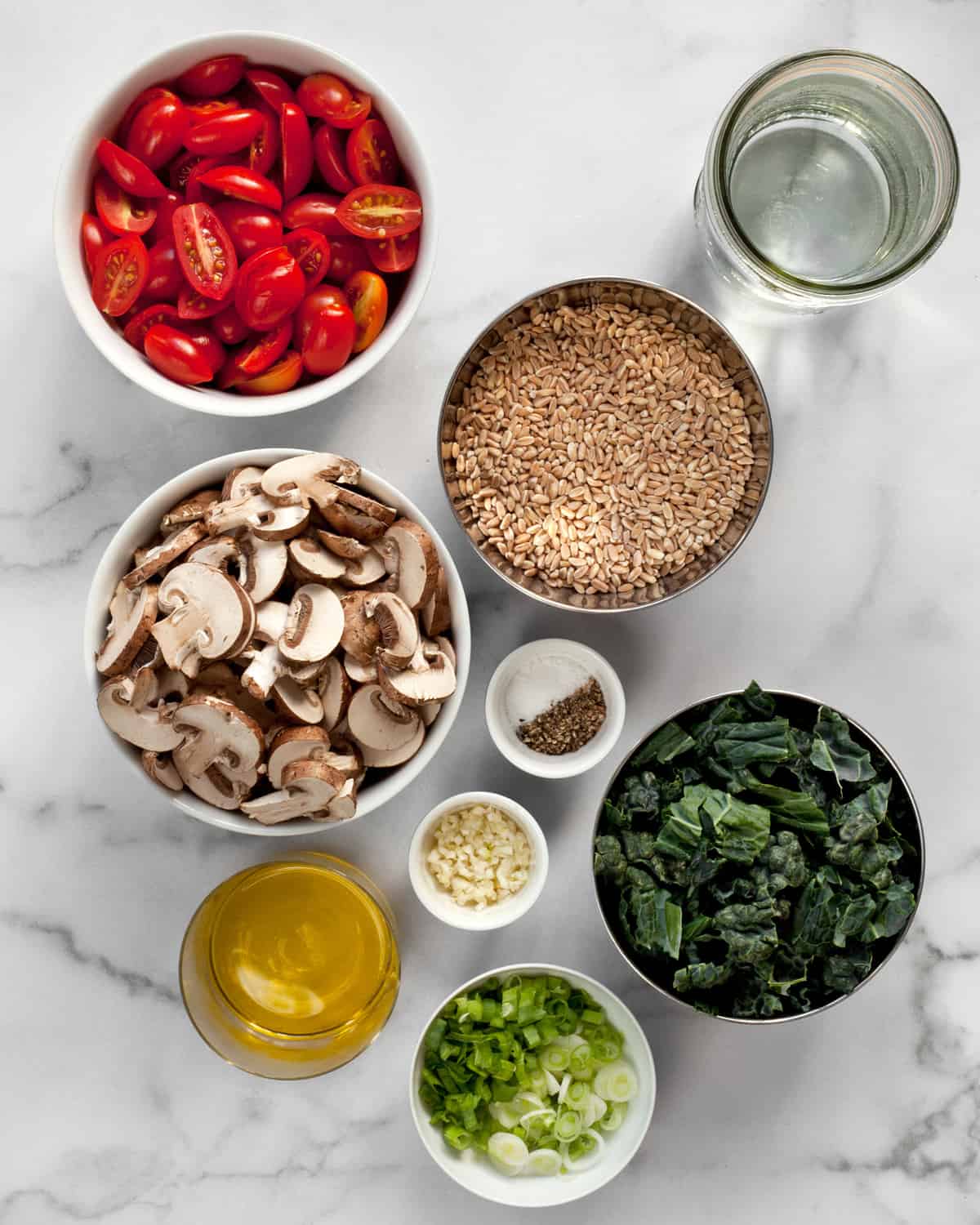 Ingredients including mushrooms, tomatoes, farro, scallions, garlic and olive oil.