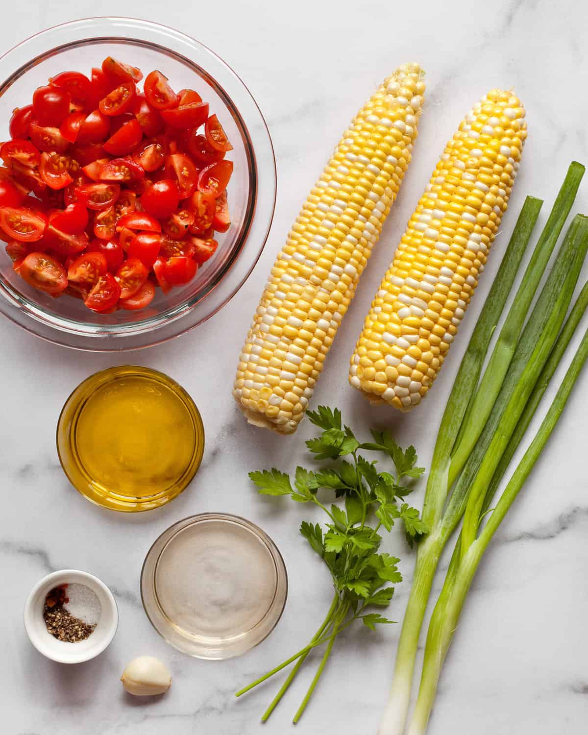 Ingredients including tomatoes, corn, scallions, parsley, olive oil, and vinegar.
