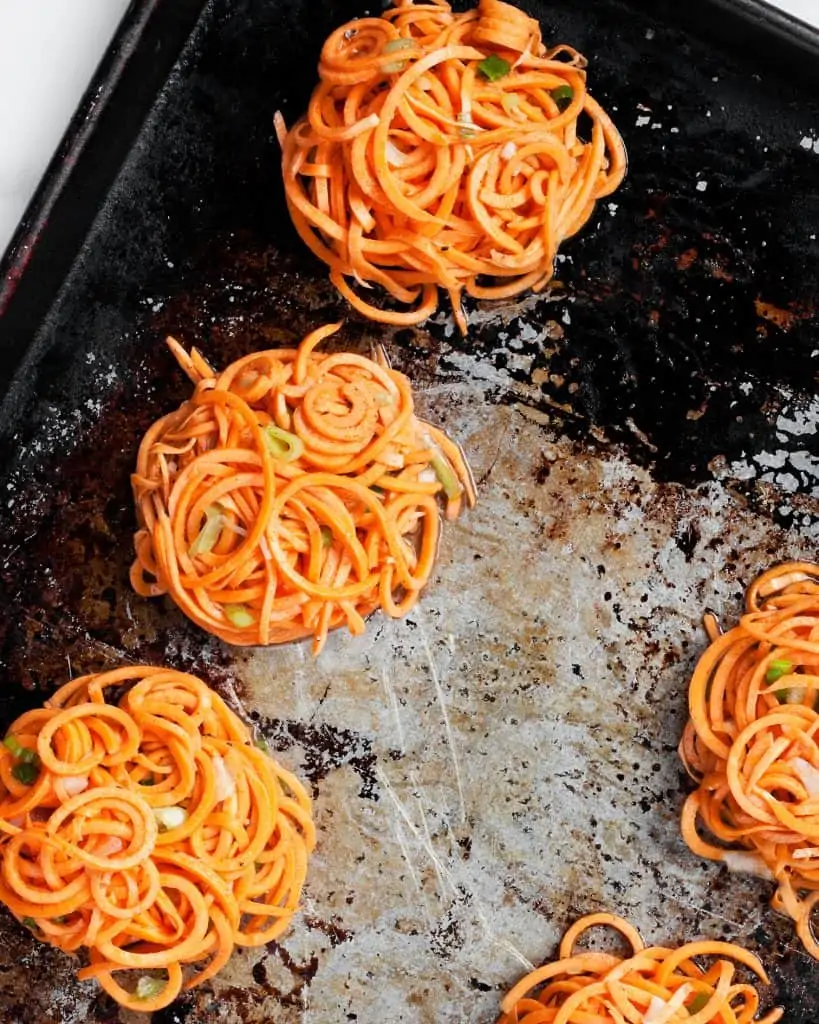 Sweet potato fritters on a sheet pan before they are baked